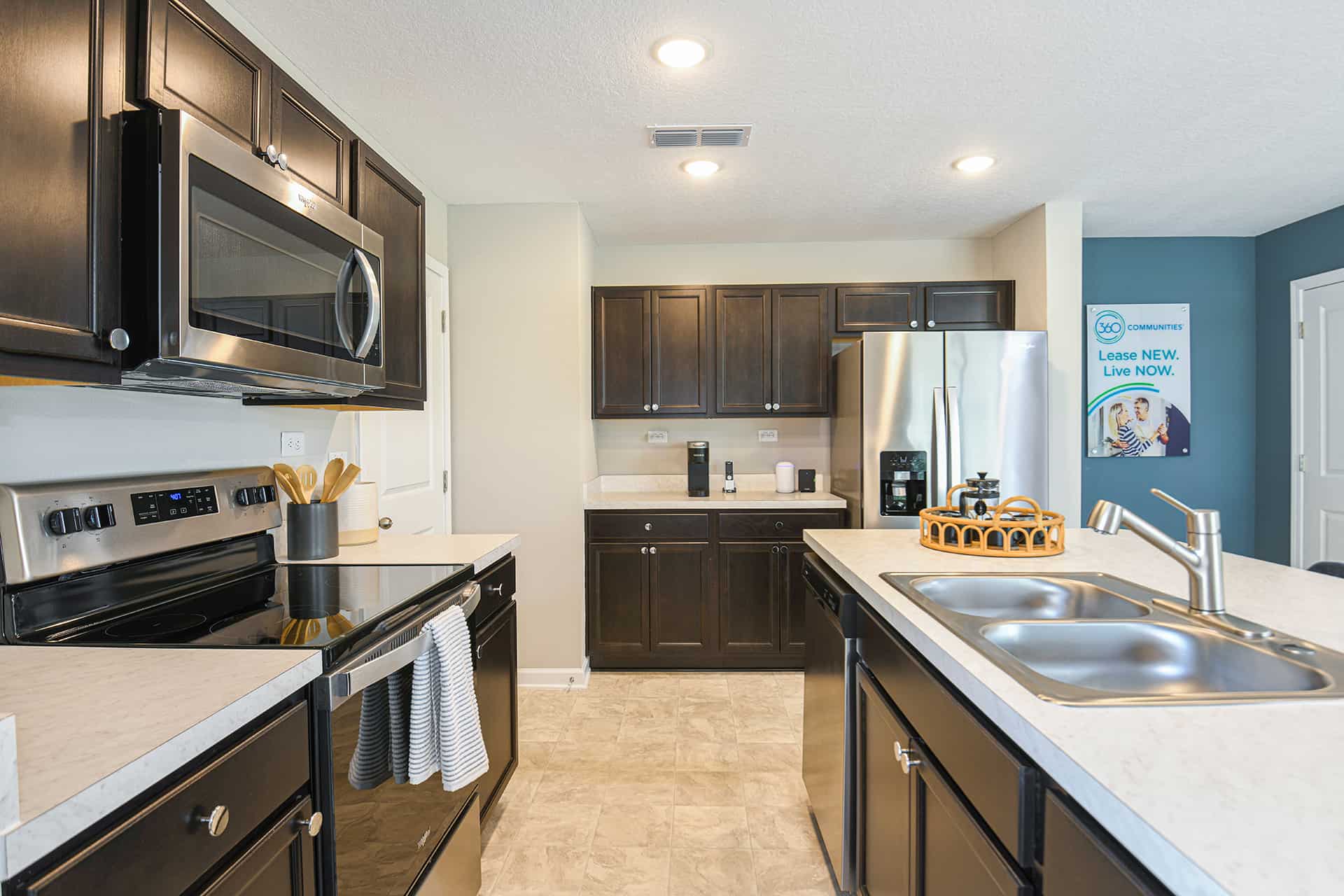 Townhouses for Rent in Jacksonville, FL - Liberty Square - Kitchen with Tile Floors, Stainless Steel Appliances, Dark Wood-Style Cabinets, Light Countertops, and a middle Island